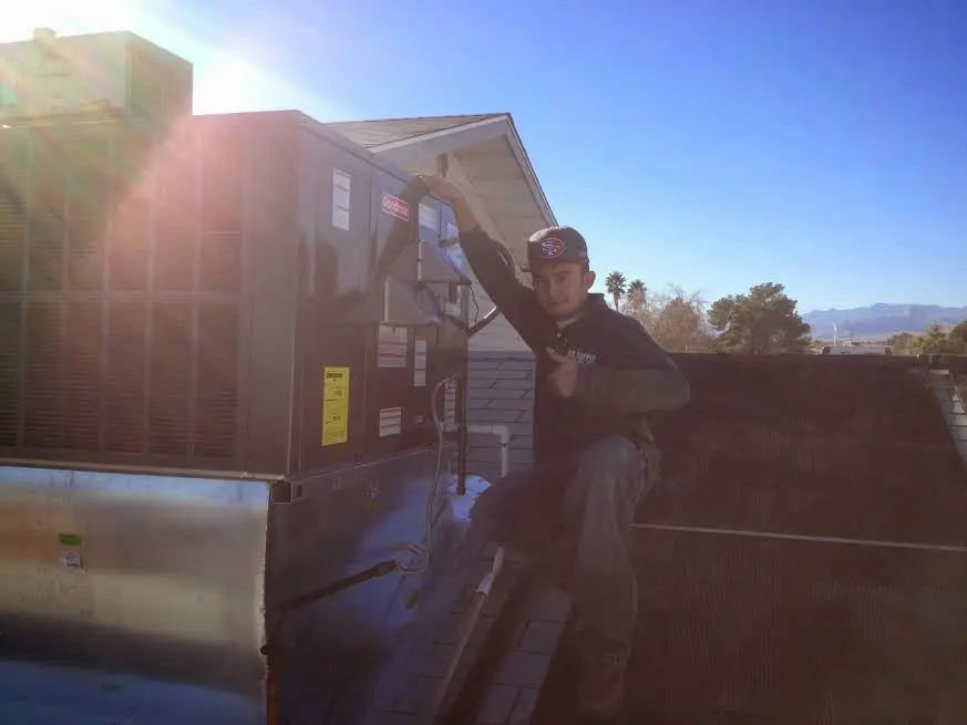 HVAC technician performing HVAC Inspection on a rooftop unit in Bennington